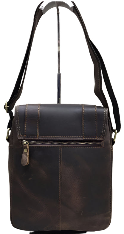 Brown leather satchel bag with visible stitching and hardware on a wooden surface.