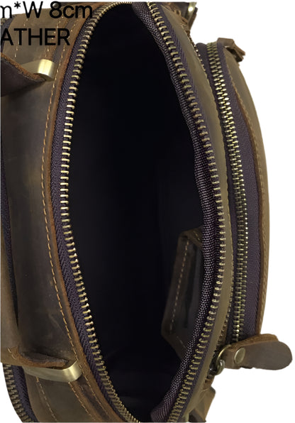 Brown leather bag with shoulder strap on a wooden floor background