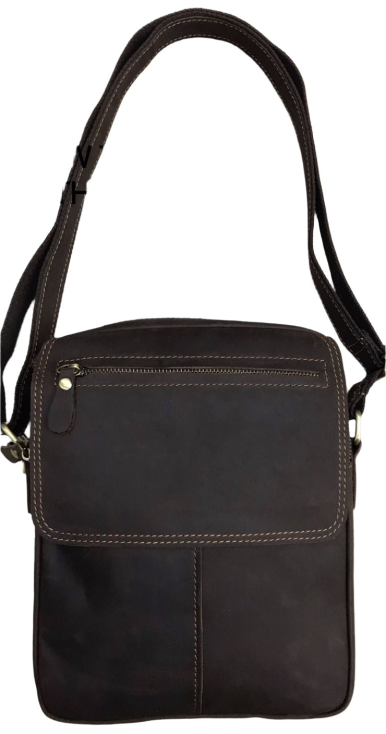 Brown leather crossbody bag on a light wood background