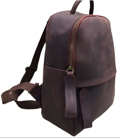 Brown leather backpack shown from multiple angles on a light wooden surface.